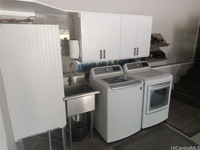 laundry room featuring sink, washer and dryer, and cabinets