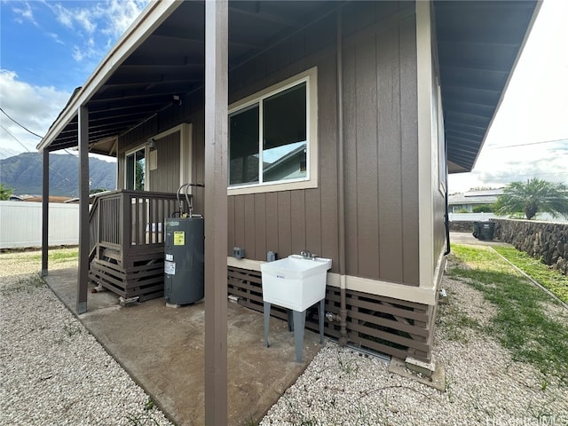 view of patio / terrace with sink, electric water heater, and a mountain view