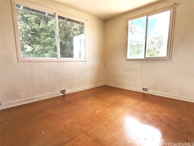 unfurnished room with wood walls