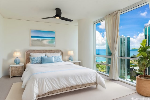 bedroom featuring carpet, a water view, and ceiling fan