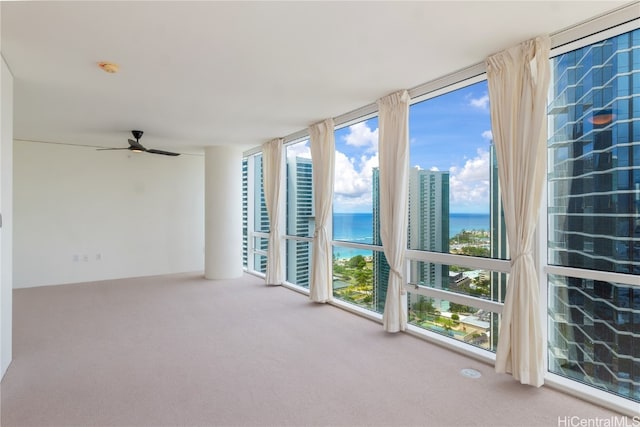 unfurnished sunroom featuring a water view and ceiling fan