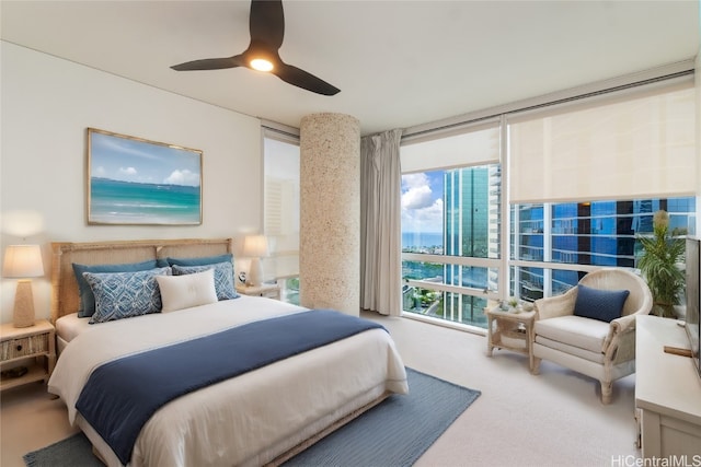 bedroom with expansive windows, carpet flooring, and ceiling fan