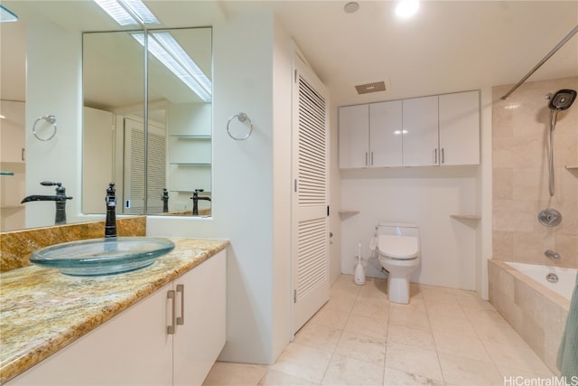 full bathroom featuring toilet, tiled shower / bath combo, vanity, and tile patterned flooring