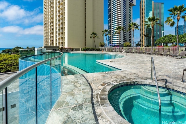 view of swimming pool with a hot tub and a patio area