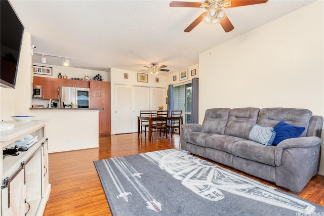 91-940 Puahala St Unit 39T, Ewa Beach, HI 96706 - living room featuring ceiling fan, light wood-type flooring, and a textured ceiling
