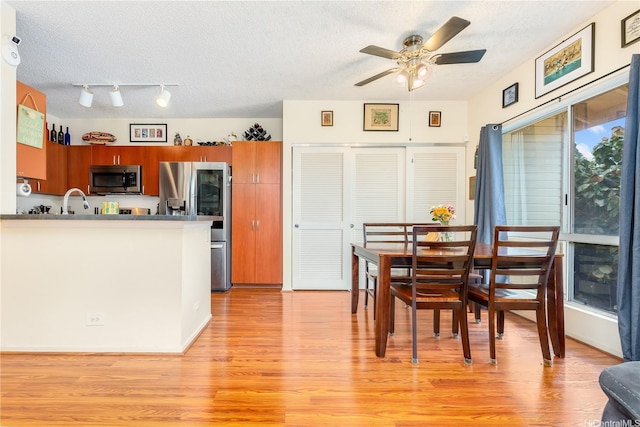 91-940 Puahala St Unit 39T, Ewa Beach, HI 96706 - kitchen featuring brown cabinets, ceiling fan, appliances with stainless steel finishes, a textured ceiling, and light wood-style flooring