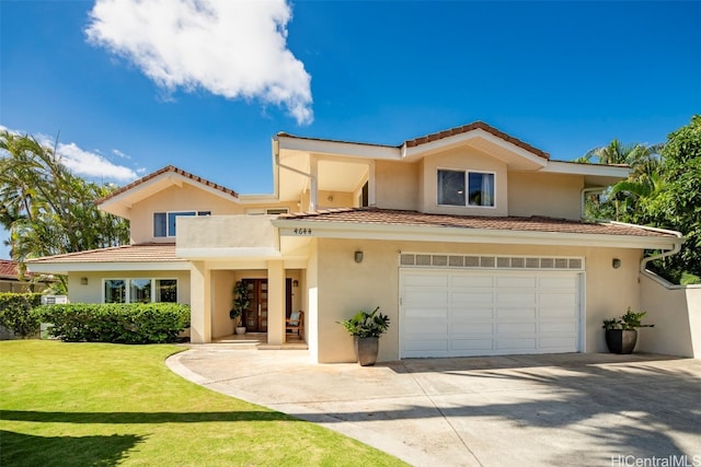 mediterranean / spanish house with a front yard and a garage