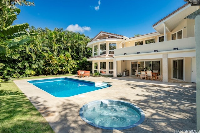 view of swimming pool with an in ground hot tub and a patio