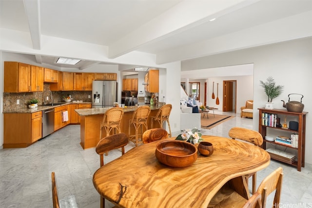 dining room with beamed ceiling and sink