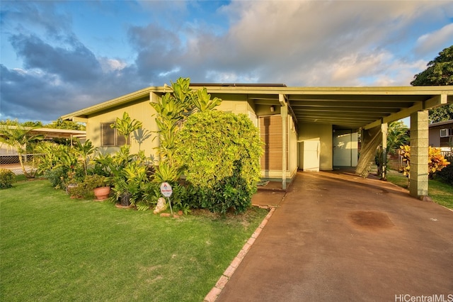 view of front of home with a front yard and a carport