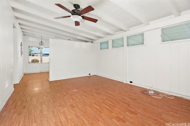 spare room featuring vaulted ceiling with beams, light wood-type flooring, and ceiling fan