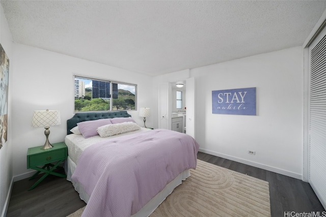 bedroom featuring hardwood / wood-style floors, a textured ceiling, and ensuite bath