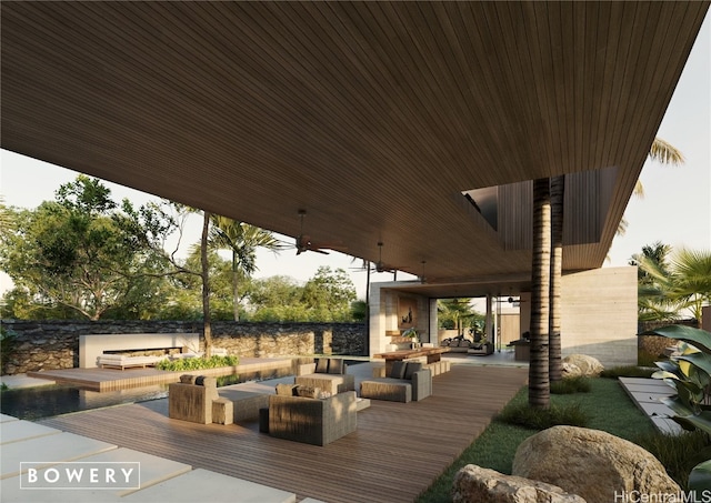 deck with an outdoor living space with a fireplace