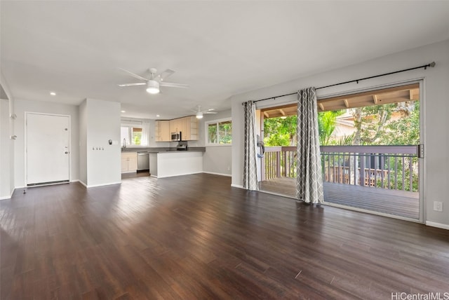 unfurnished living room featuring ceiling fan and dark hardwood / wood-style flooring