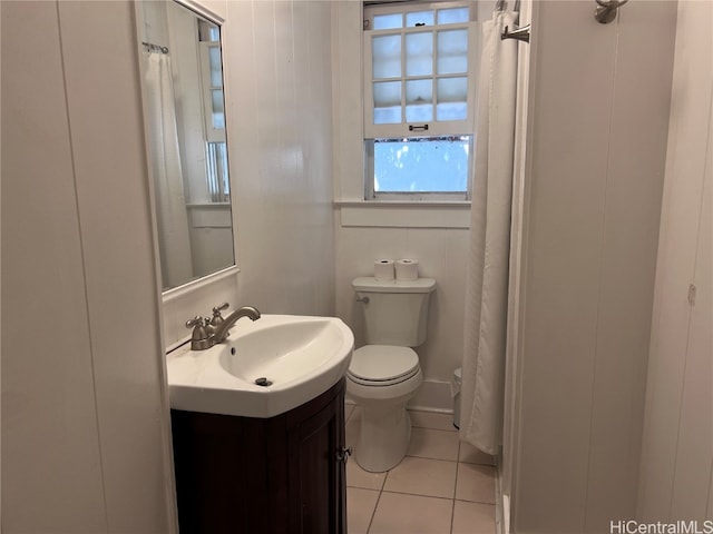 bathroom featuring wood walls, vanity, toilet, and tile patterned flooring