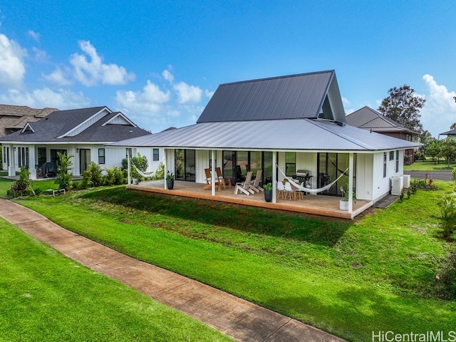 back of property with a patio area, cooling unit, and a lawn