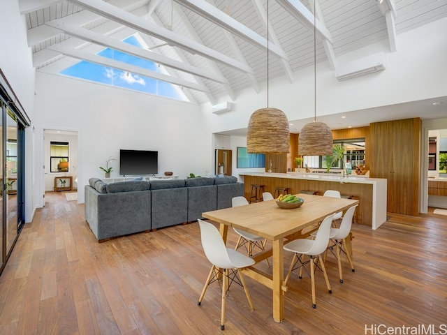 dining room featuring a healthy amount of sunlight, light hardwood / wood-style flooring, and high vaulted ceiling