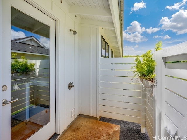 exterior space featuring vaulted ceiling with beams and carpet floors