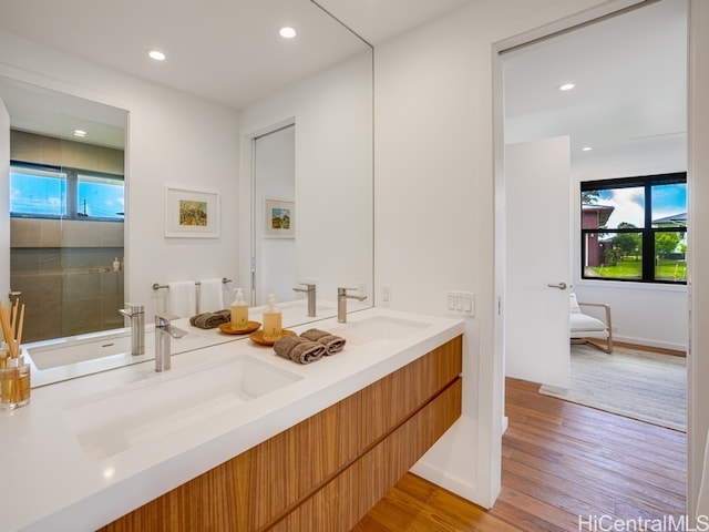 bathroom with vanity, hardwood / wood-style flooring, and a shower