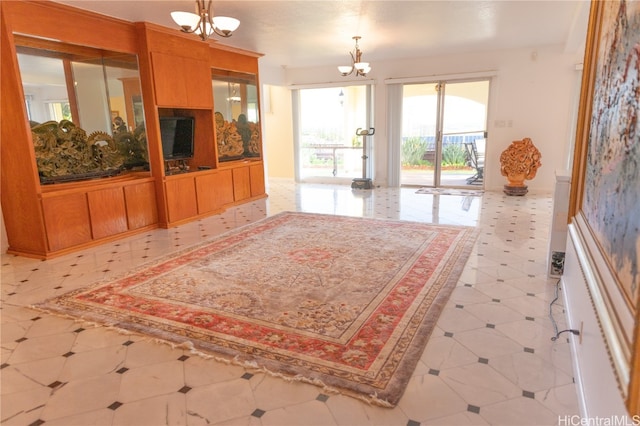 unfurnished living room with a baseboard heating unit and a chandelier