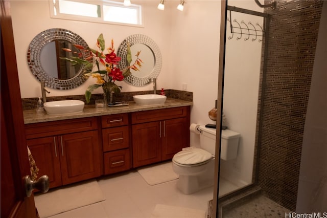 bathroom featuring vanity, toilet, tile patterned floors, and a shower with shower door