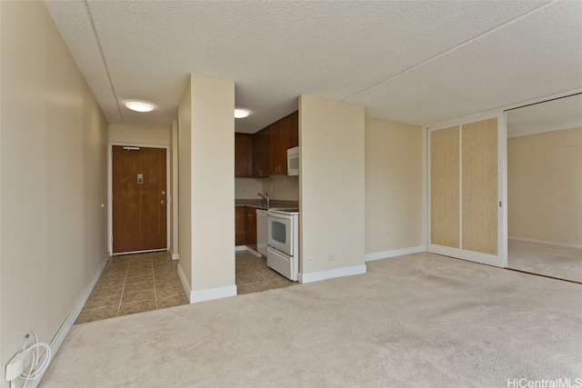 interior space featuring a textured ceiling, sink, and light colored carpet