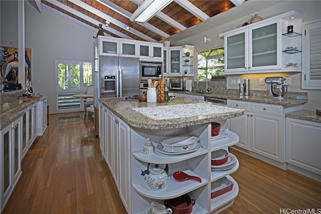 kitchen featuring a center island, lofted ceiling with beams, appliances with stainless steel finishes, white cabinetry, and wood ceiling