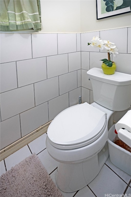 bathroom featuring tile patterned floors, toilet, and tile walls