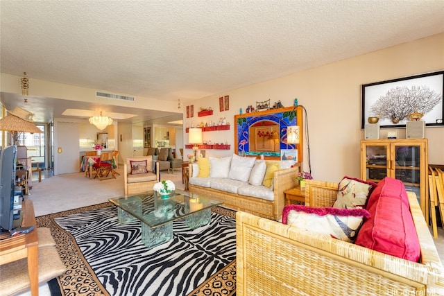 carpeted living room featuring an inviting chandelier and a textured ceiling