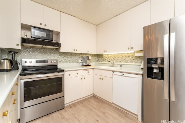 kitchen with a textured ceiling, stainless steel appliances, white cabinets, light hardwood / wood-style flooring, and exhaust hood