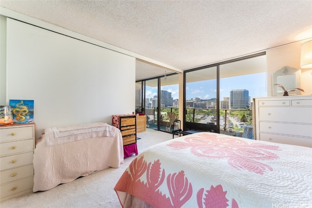 bedroom featuring expansive windows, a textured ceiling, light colored carpet, and access to exterior