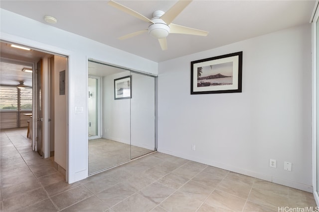 unfurnished bedroom featuring light tile patterned floors, ceiling fan, and a closet