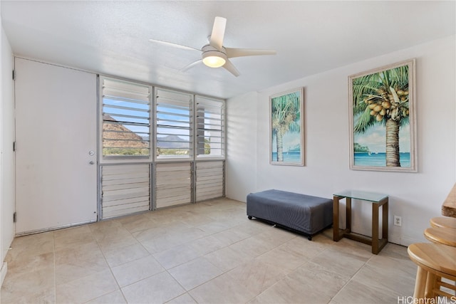 sitting room featuring light tile patterned flooring and ceiling fan