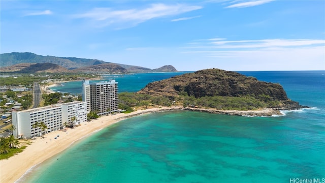 drone / aerial view featuring a water and mountain view and a beach view