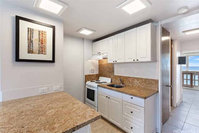 kitchen featuring white cabinetry, sink, light tile patterned floors, and electric range