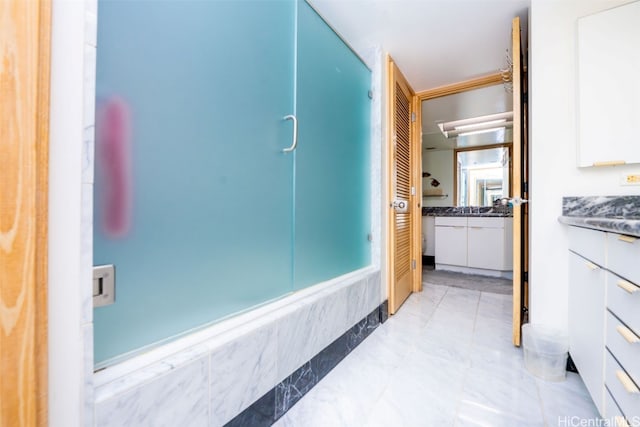 bathroom featuring a shower with door and vanity