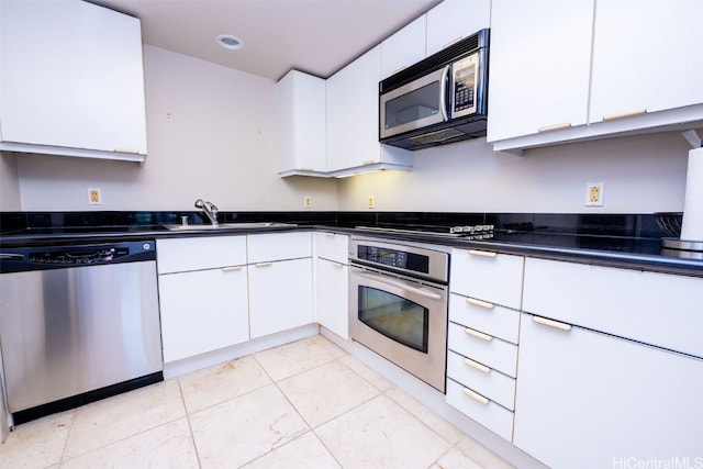 kitchen with stainless steel appliances, sink, and white cabinets