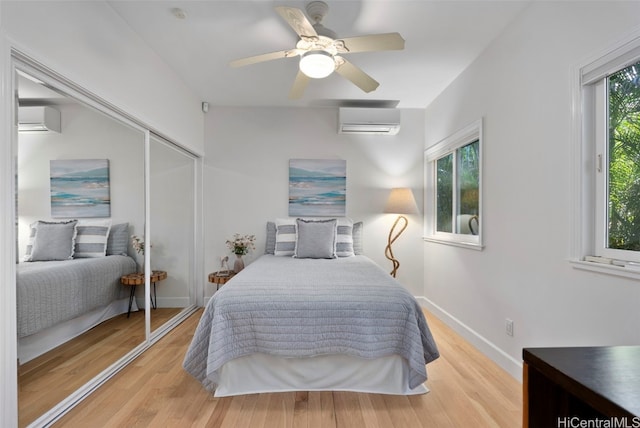 bedroom featuring light wood-type flooring, multiple windows, a closet, and ceiling fan