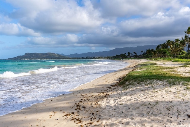 view of water feature with a mountain view and a view of the beach