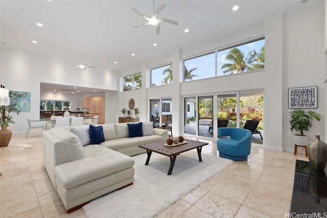 living room featuring ceiling fan and a towering ceiling