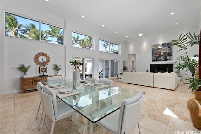 dining room with a towering ceiling and ceiling fan