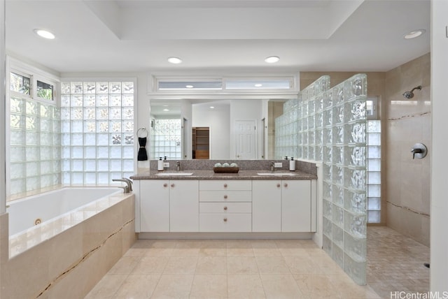 bathroom with vanity, shower with separate bathtub, a raised ceiling, and tile patterned flooring