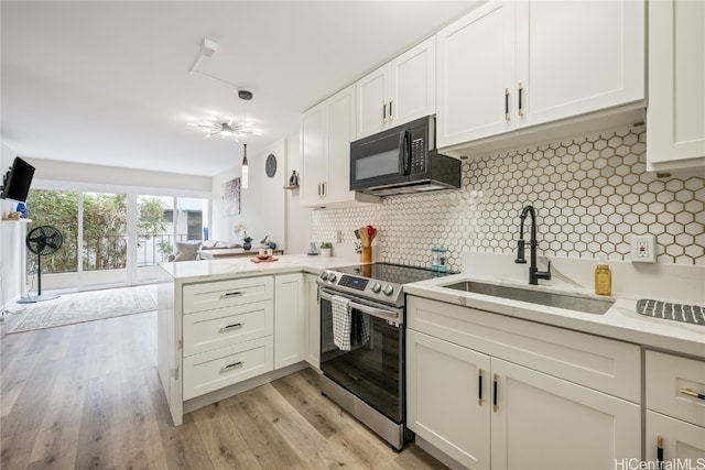 kitchen with kitchen peninsula, tasteful backsplash, electric range, light wood-type flooring, and sink