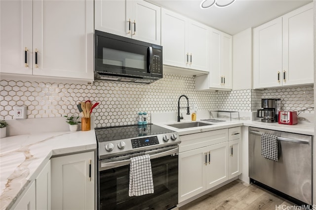 kitchen with sink, white cabinets, stainless steel appliances, and backsplash