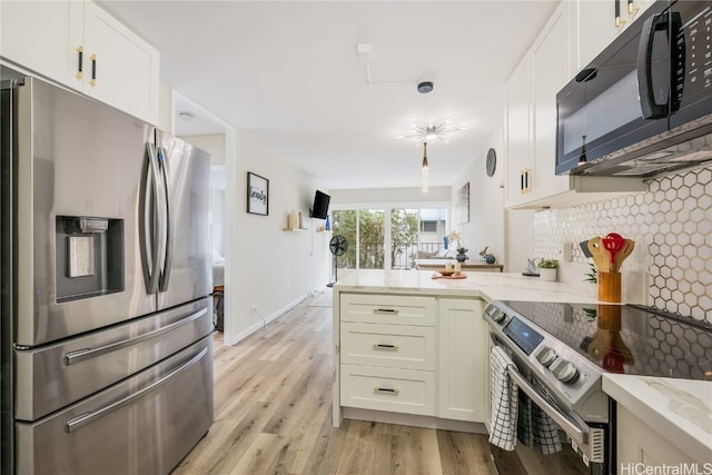 kitchen with kitchen peninsula, backsplash, appliances with stainless steel finishes, light wood-type flooring, and light stone counters