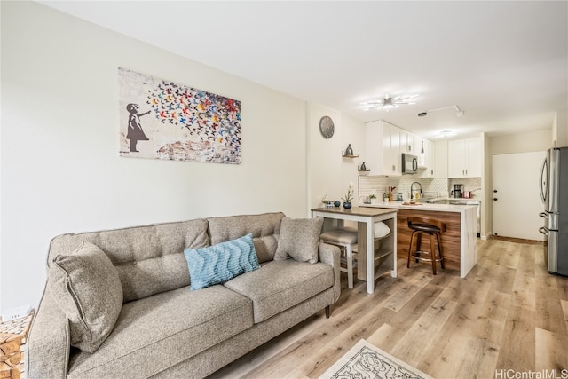 living room featuring light hardwood / wood-style floors and sink