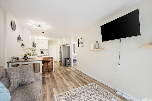 living room featuring sink and light wood-type flooring