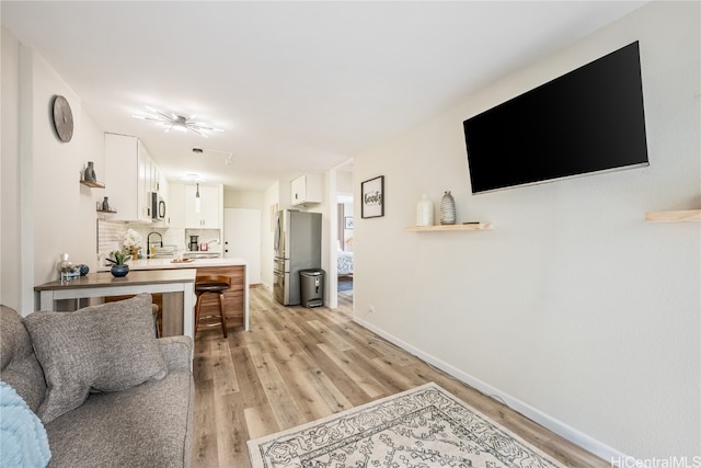 living room with sink and light wood-type flooring