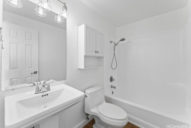 full bathroom featuring sink, tub / shower combination, and toilet