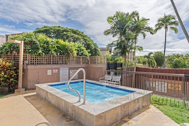 view of swimming pool with a hot tub